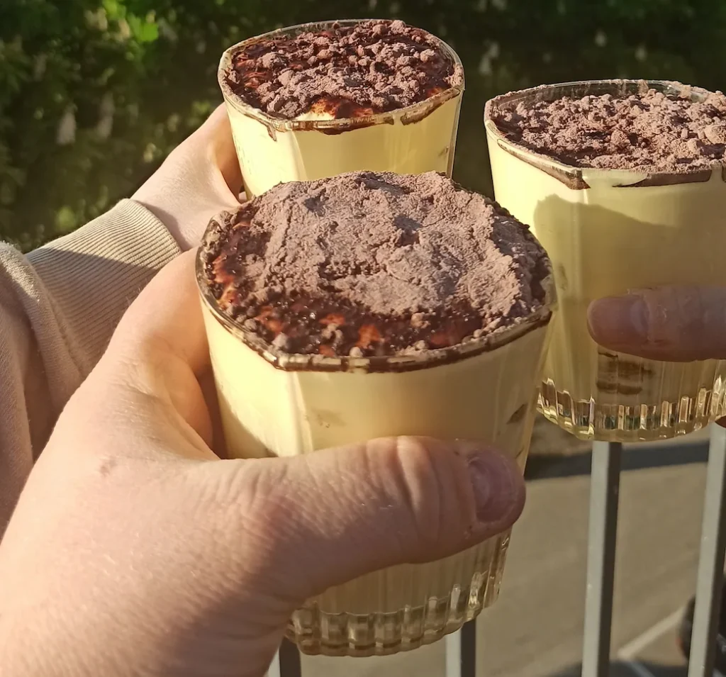 tiramisu cup recipe-3 hands holding individual tiramisu cups in the open air