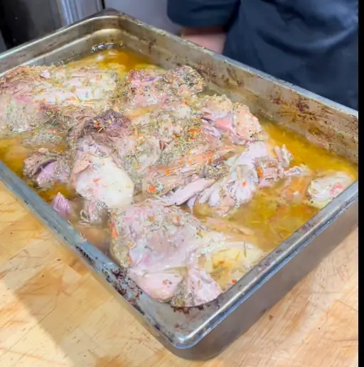Juicy pulled pork being shredded with forks