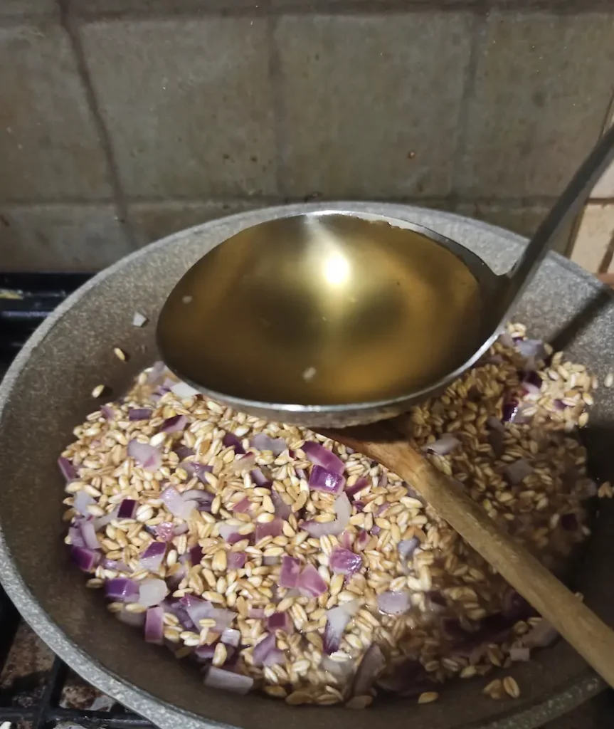 adding chicken stock to farrotto