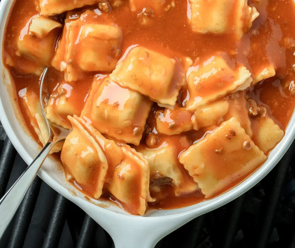 a baking dish full with ravioli and tomato sauce