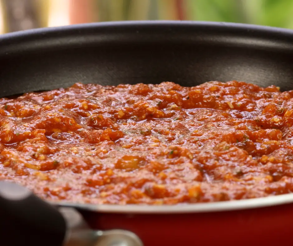 how to thicken marinara sauce-a thick tomato sauce heating in a saucepan