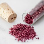 homemade red wine flavored coarse salt next to a little bottle and a cork