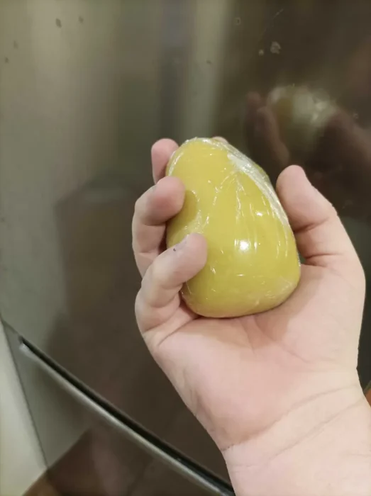 a pastry dough ball covered with plastic wrap