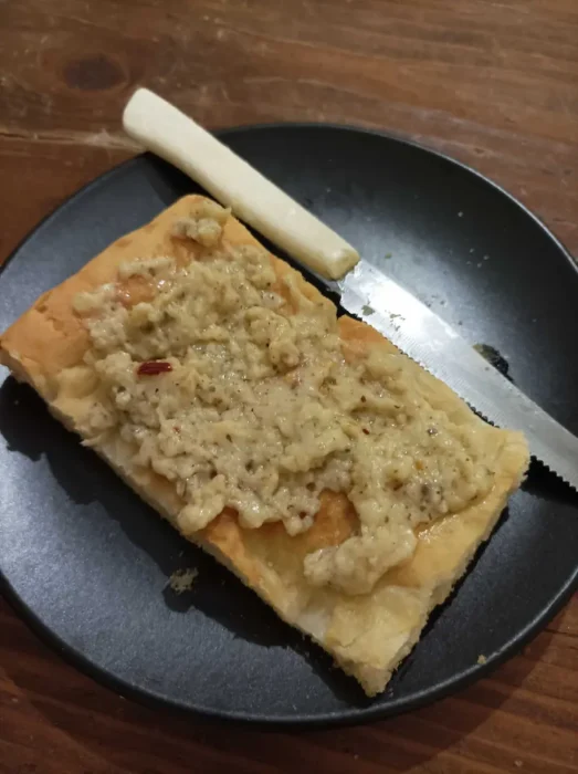 a thick crust pizza topped with creamy garlic sauce