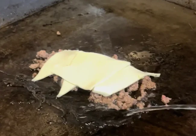 letting slices of cheese melt on the meat