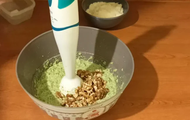 adding walnuts to cabbage pesto