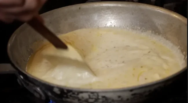 Creamy white sauce simmering in a saucepan
