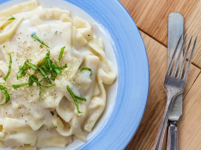 Thick Alfredo sauce coating pasta noodles