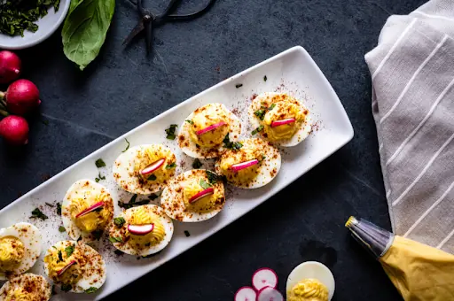 deviled eggs ready to be served as an appetizer with some wine