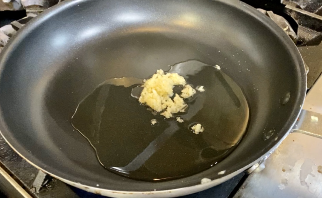 grated garlic sauteeing in a pan