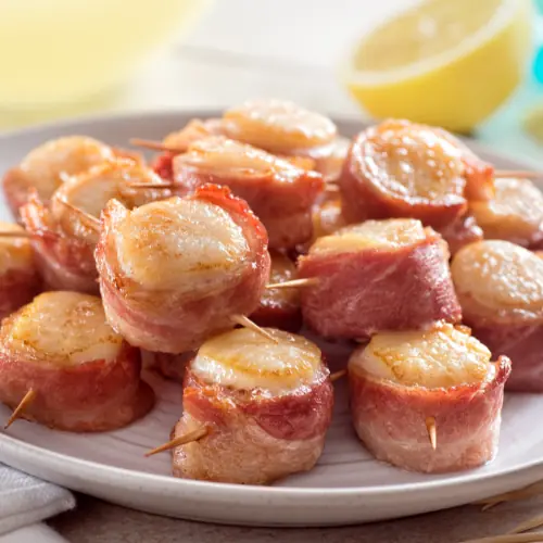 seafood finger food-bacon wrapped scallops on an appetizer dish