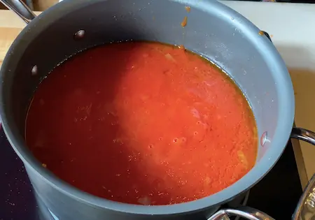 Meatballs simmering in tomato sauce on the stove