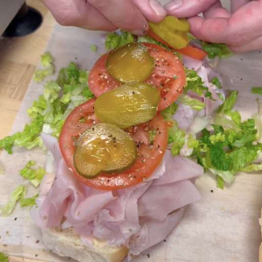 Sliced ham layered with cheese on fresh bread