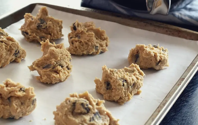 cookie dough balls on a baking tray lined with parchment paper
