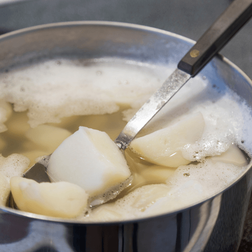 Fork testing tenderness of boiled potatoes