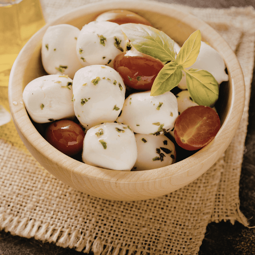 Mozzarella balls with cherry tomatoes and basil in bowl