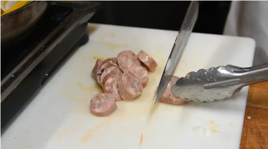 Sausage, peppers, and onions sizzling together in a skillet