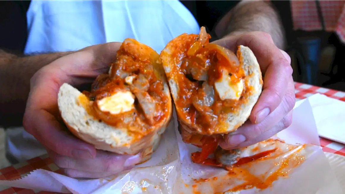 Hoagie roll stuffed with sausage, peppers, and onions